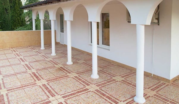 Terraza con piso de cerámica y columnas blancas